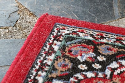 corner of old red-edged rug