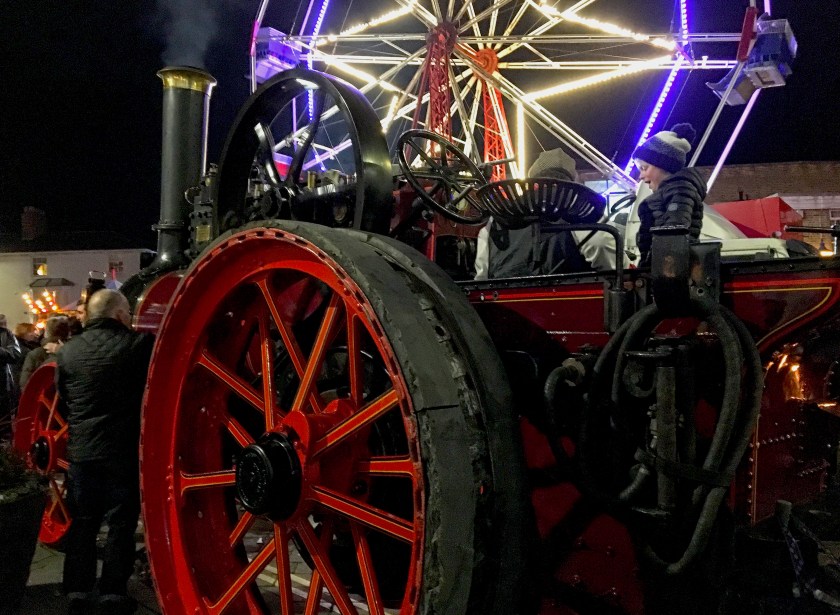 old steam engine with modern ferris wheel behind