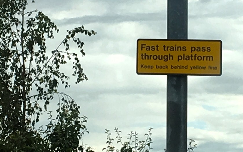 Railway sign: fast trains pass through station