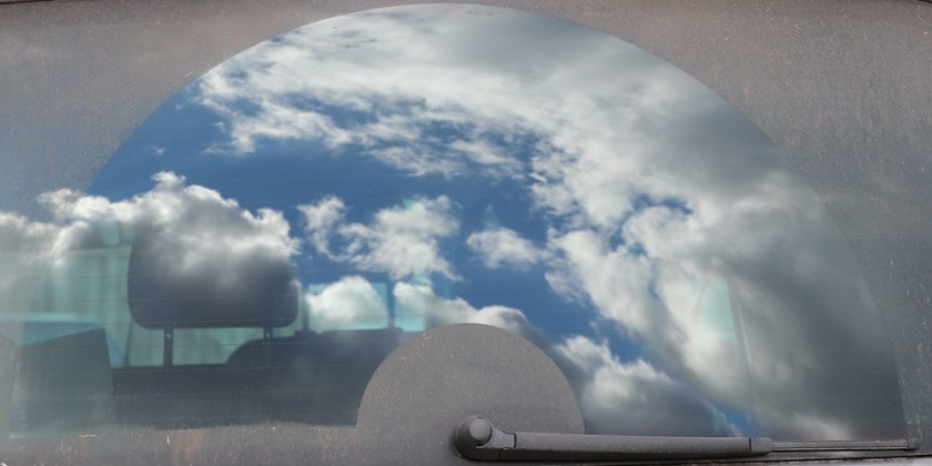 clouds reflected in car rear window
