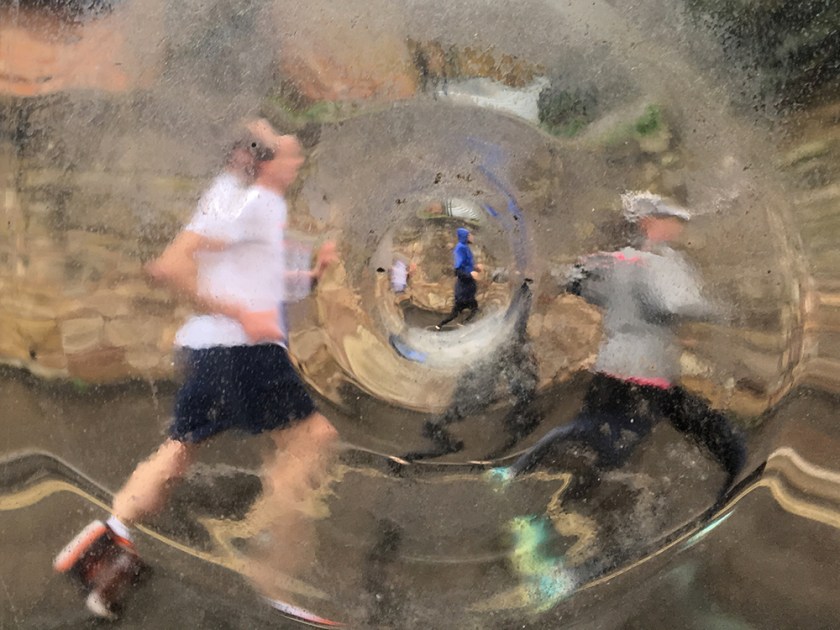 marathon runners seen through distorting window
