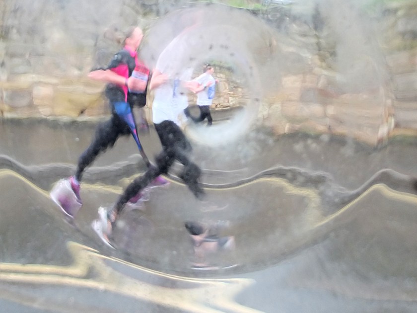 marathon runners seen through distorting window
