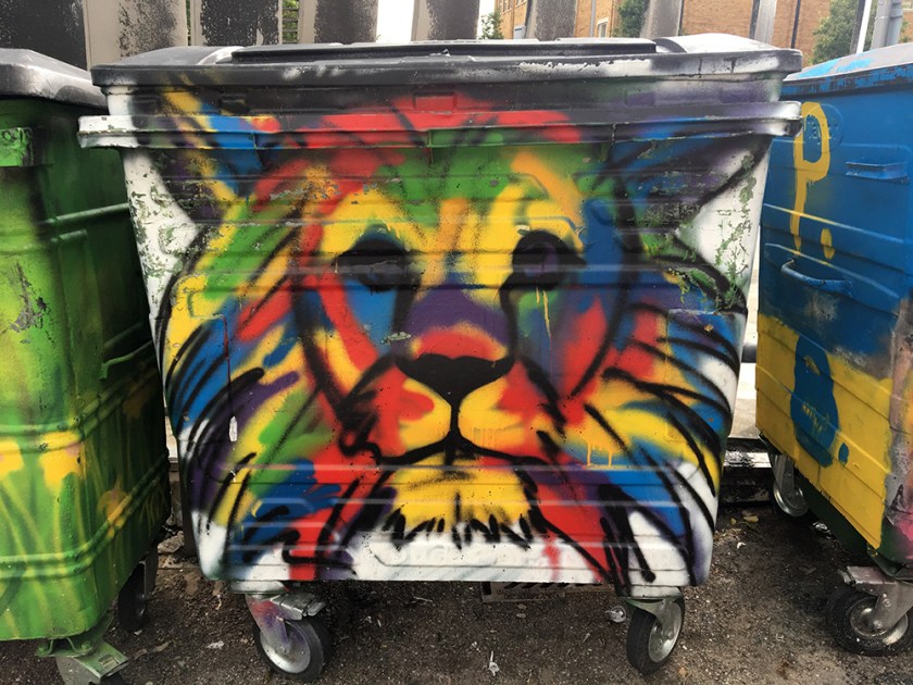 multicoloured lion graffiti on community bin