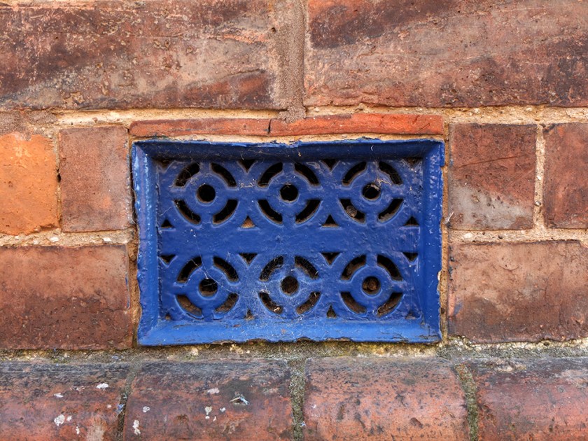 blue metal grating. Red brick wall