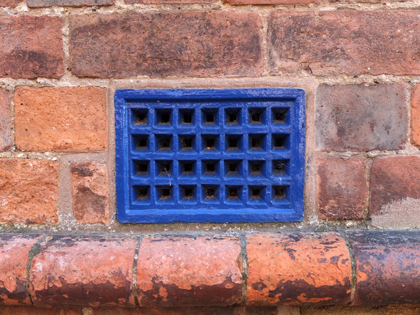 blue metal grating. Red brick wall