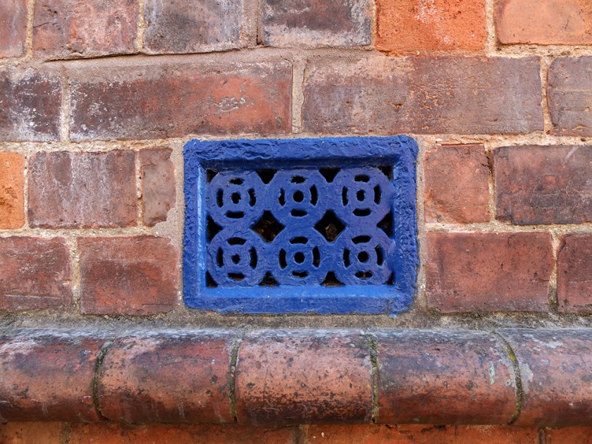 blue metal grating. Red brick wall