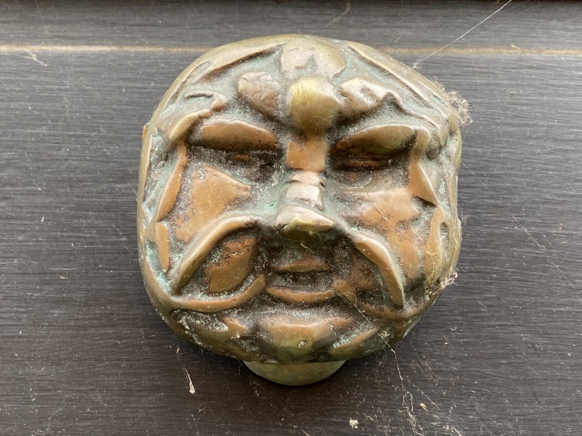 Old metal door knob with green man face